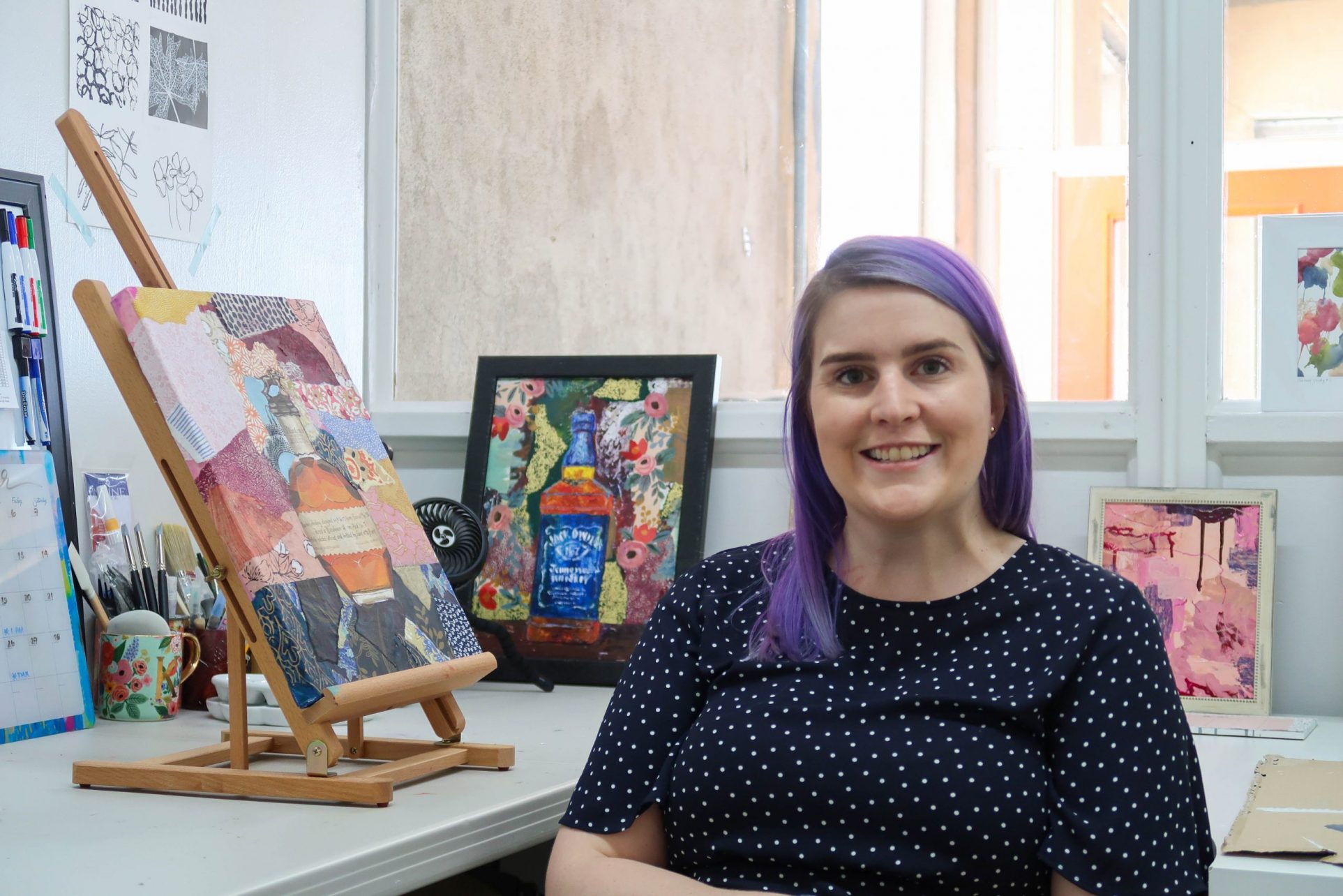 Katie Wampler with paintings in studio